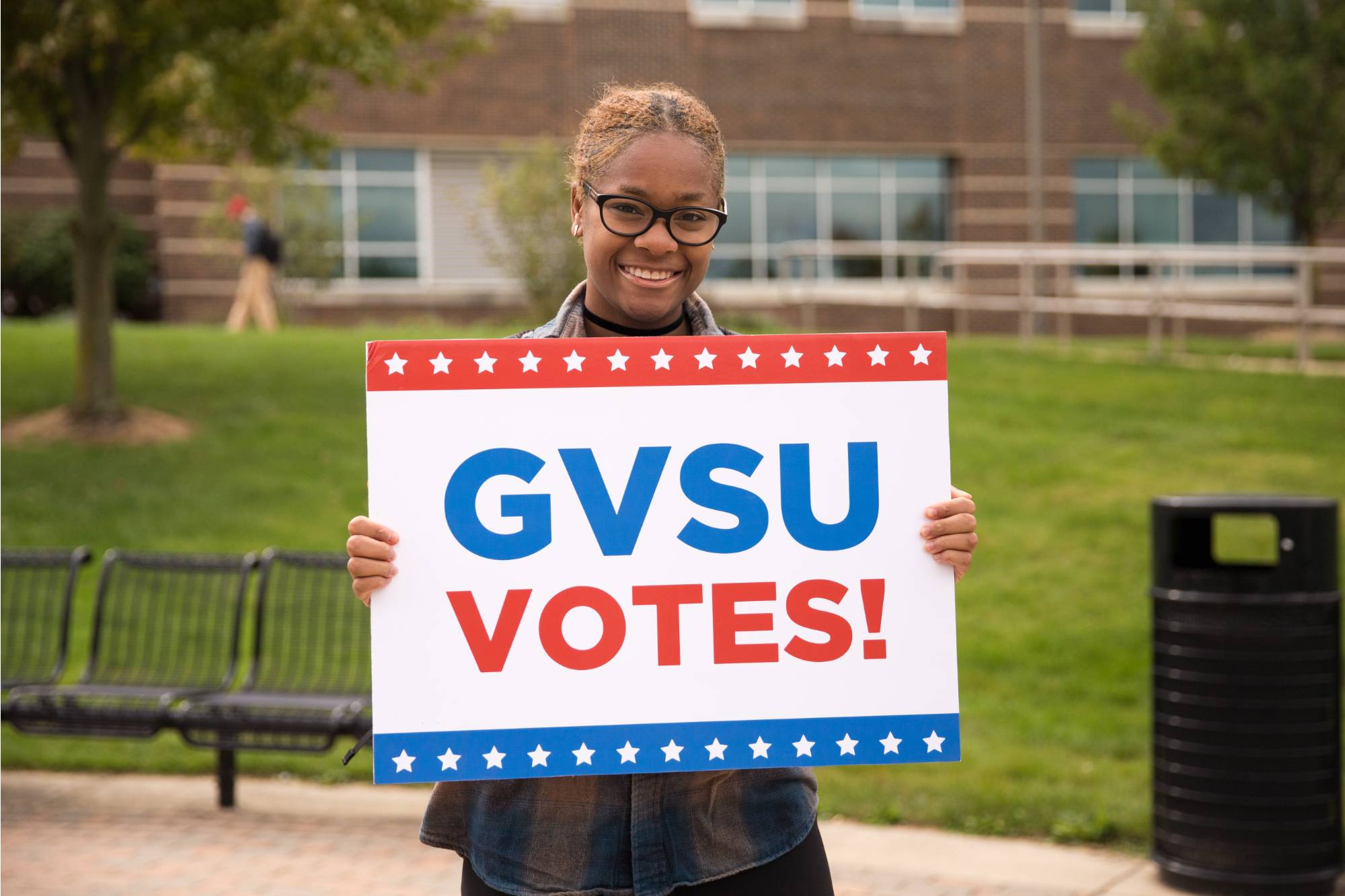 Student with sign and text GVSU Votes